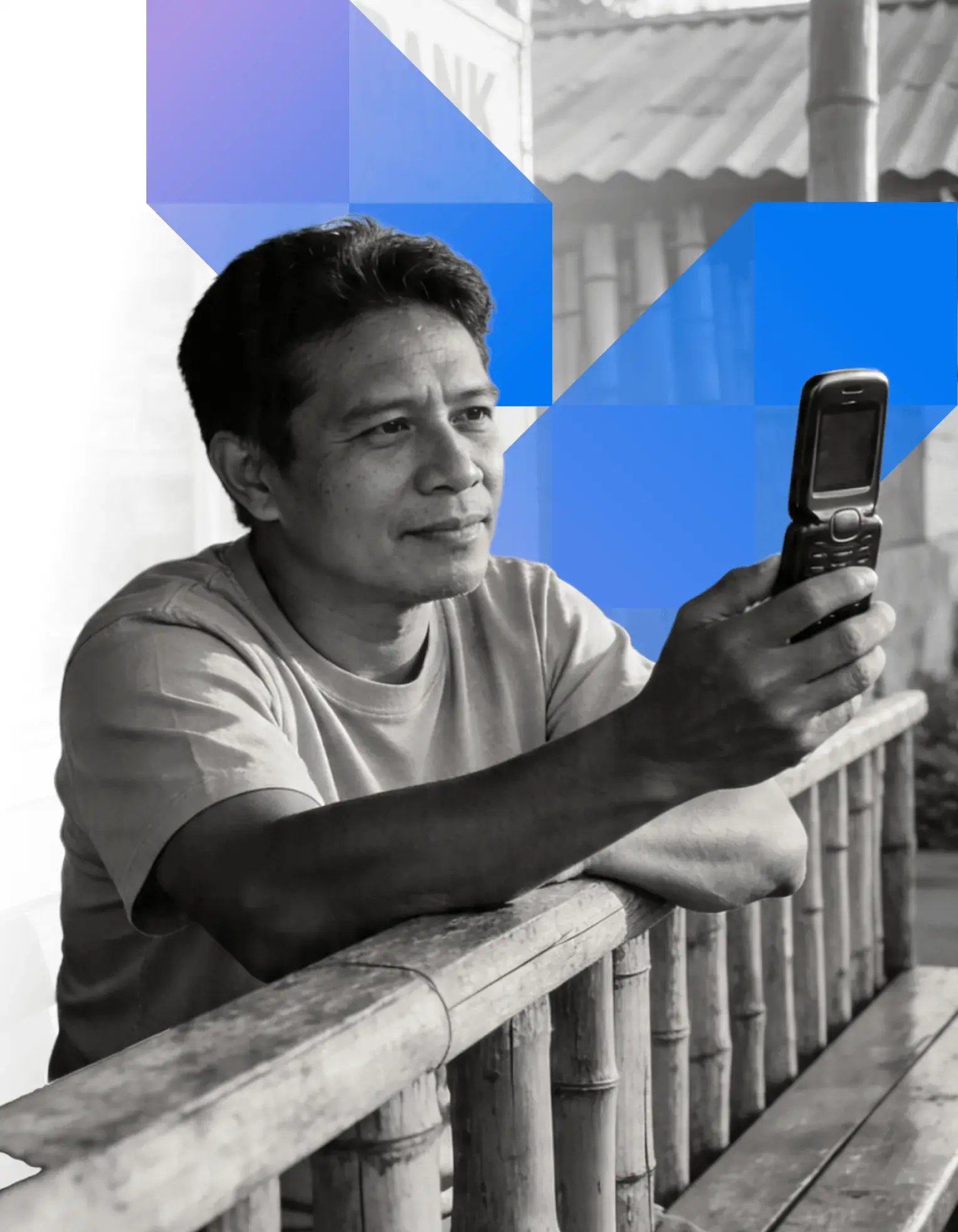 A man using a basic mobile phone outside a rural bank — community and regional banks segment